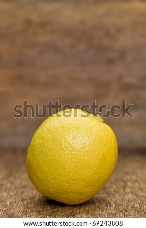 Single lemon on a wooden background