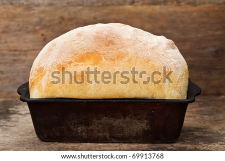 Freshly cooked white bread still in the bread pan