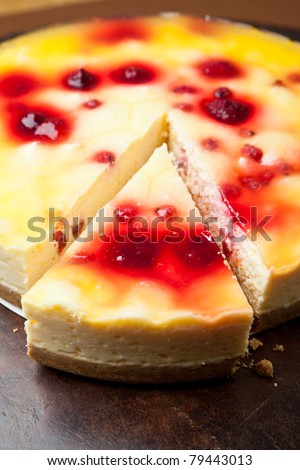 Raspberry cheesecake on a digestive biscuit crumb topped with an orange glaze.