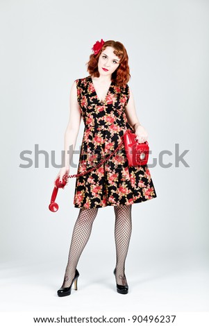 Vintage styled woman holding a UK red phone