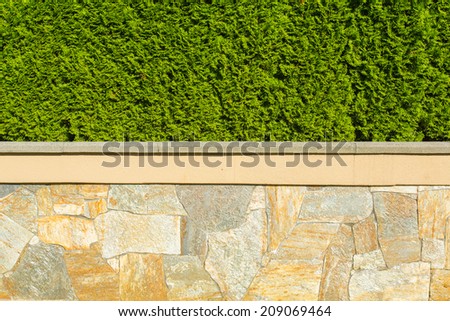 Big isolated natural fence around a house made of stone and nicely trimmed green belt