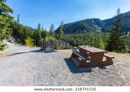 Rest area with a wooden picnic table at Cheakamus Lake Park in British Columbia, Canada.