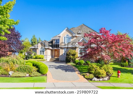 Custom built luxury house with nicely trimmed front yard, lawn in a residential neighborhood. Vancouver Canada.