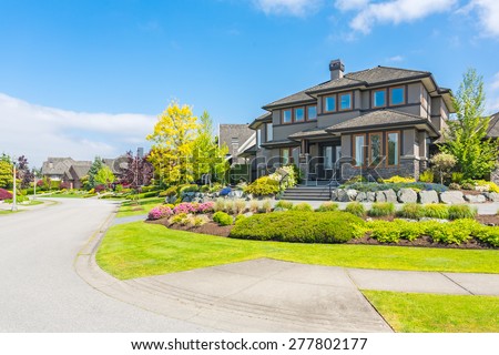 A perfect neighborhood on a sunny day with blue sky. Houses and townhouses in suburbs at Spring in the north America.