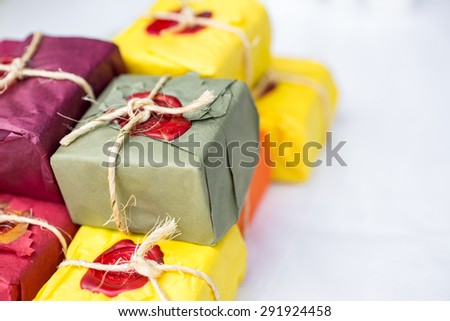 Hand made soap on white cloth in paper packaging. Isolated, white background, wax sealed and stamped.