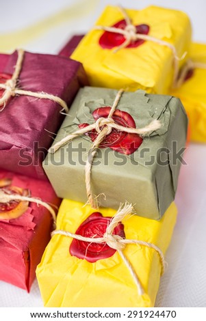 Hand made soap on white cloth in paper packaging. Isolated, white background, wax sealed and stamped.