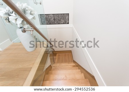 Stairs to the second floor in a luxury house with a flower vase, decoration. Interior design.