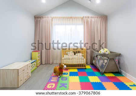 Interior design of a nursery room with a crib and toys.