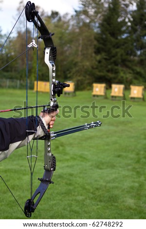 a hand holding a compound bow