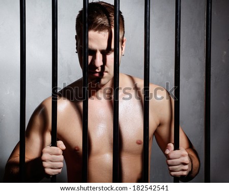 Sexy man behind iron prison bars