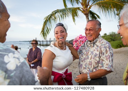 Hawaiian beach bride laughing it up with friends and family.