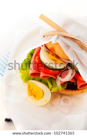 Baked garlic ciabatta sandwich with fresh salad tomato onion egg and sausage as supplement