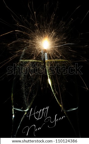 New Year firework celebration with rockets exploding high in the night sky and Happy New Year text below