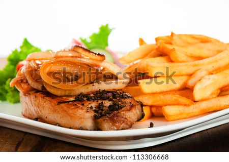 A menu with meat french potatoes roasted onion and salad on white plate