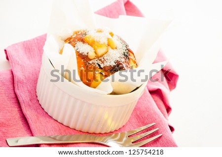 caramel muffin wrapped in baking paper in a ramekin on a pink napkin