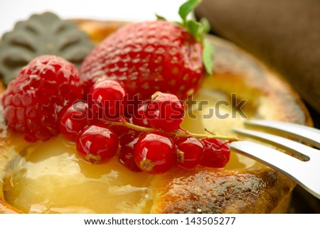 a small apple tart with strawberry currant and a piece of black chocolate