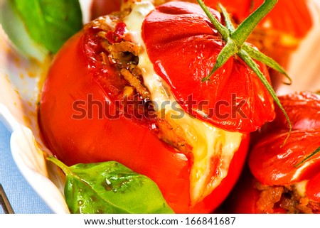 Three stuffed tomatoes on a white plate