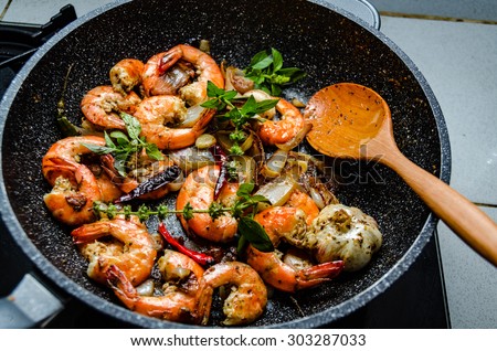 Shrimps served on a pan with fresh herbs
