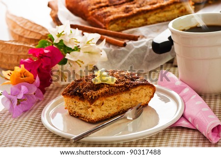 A sheet cake with cinnamon sugar butter and a hot cup of coffee