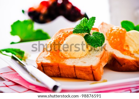 Breakfast with french toast butter and jam on a white plate