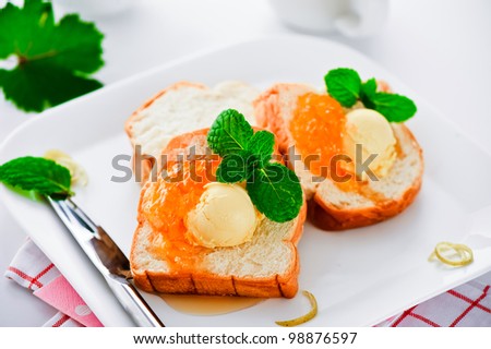 Breakfast with french toast butter and jam on a white plate