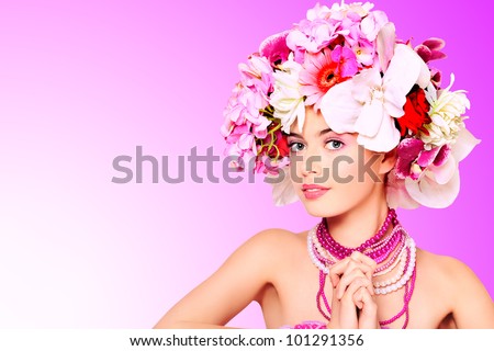 Portrait of a beautiful spring girl wearing flowers hat. Studio shot.