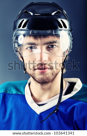 Portrait of a handsome ice-hockey player. Studio shot.