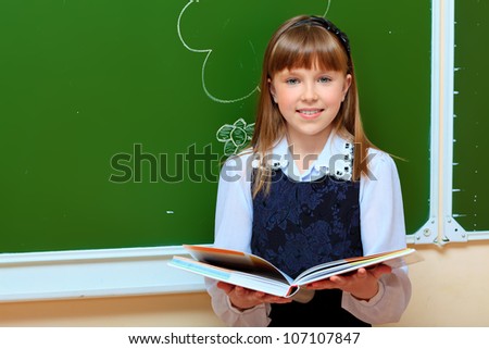 Portrait of a smiling schoolgirl in a classroom.