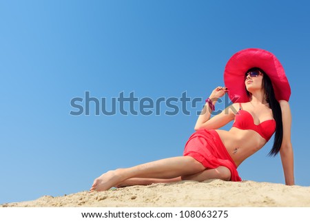 Beautiful young woman in bikini on a sunny beach.