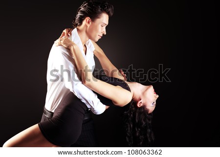 Beautiful couple of professional artists dancing passionate dance.