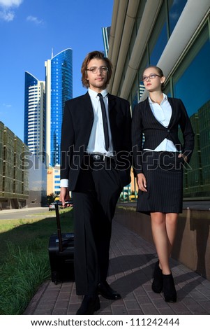 Business man and business woman are walking the streets of the big city.