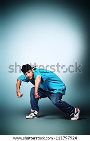 Trendy young man dancing hip-hop at studio.
