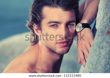 Portrait of a handsome male model posing at the seaside.