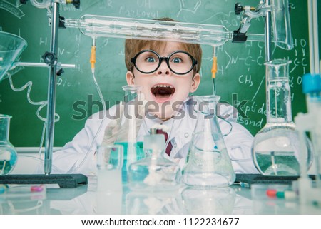 Funny school boy scientist in the laboratory. Educational concept.