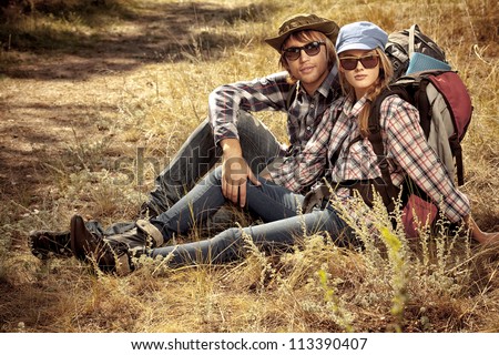 Couple of tourists having a rest on a trekking trail.