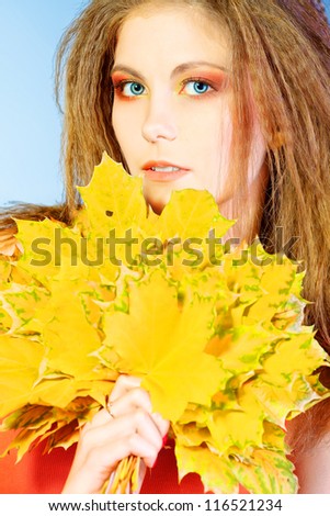 Beautiful girl holding bouquet of autumn leaves.