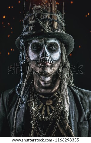 A man with a skull makeup dressed in a tail-coat and a top-hat. Baron Saturday. Baron Samedi. Dia de los muertos. Day of The Dead. Halloween.