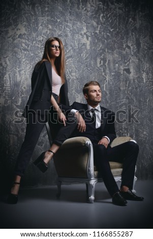 A photo of beautiful couple in studio. Classical suits. Men and women collection.