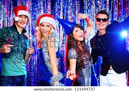 Group of cheerful young people celebrating Christmas at the nightclub.