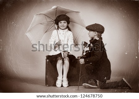 Cute Little Boy Is Giving A Rose To The Charming Little Lady. Retro Style.