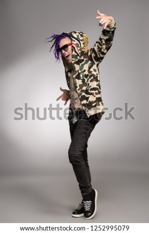 Punk rock musician posing at studio. Youth alternative culture. Full length portrait.