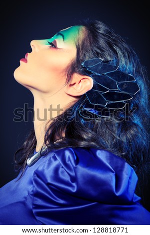Portrait of a beautiful young woman with fantasy makeup. Black background.