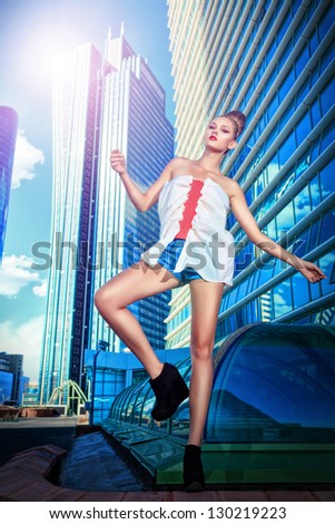 Full length portrait of a fashion model posing over big city background.