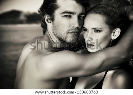 Black-and-white portrait of a sexual young couple in love having holidays on the sea.