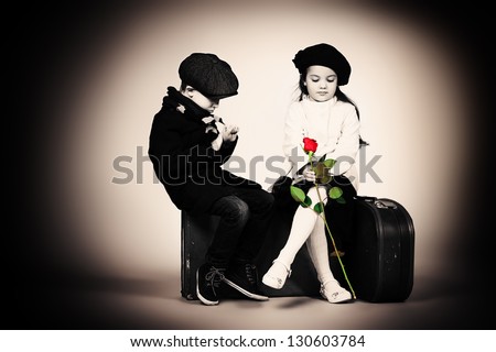 Cute little boy is giving a rose to the charming little lady. Retro style.