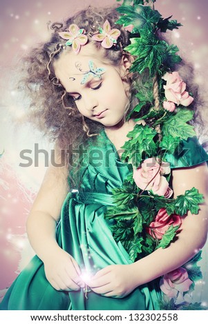Beautiful little fairy among the thickets of ivy over pink background.