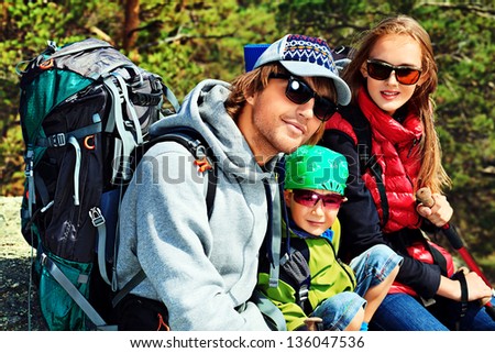 Happy parents hiking with their little son.