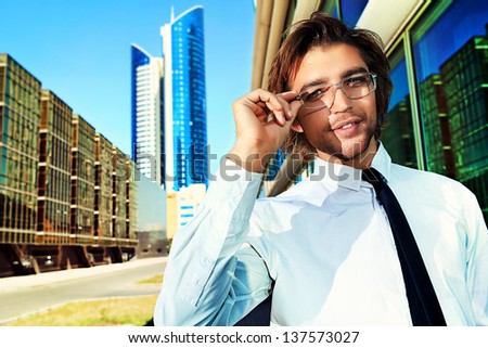 Young business man standing on the street of the big city.