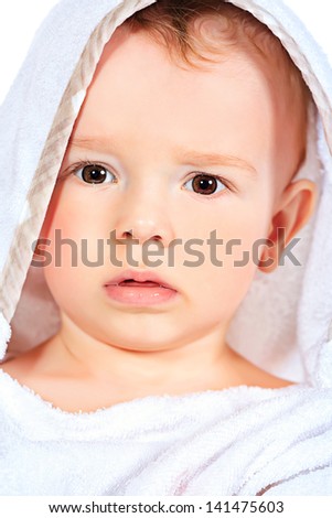 Portrait of beautiful baby in white towel. Isolated over white.