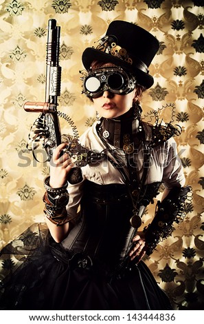 Portrait of a beautiful steampunk woman holding a gun over vintage background.